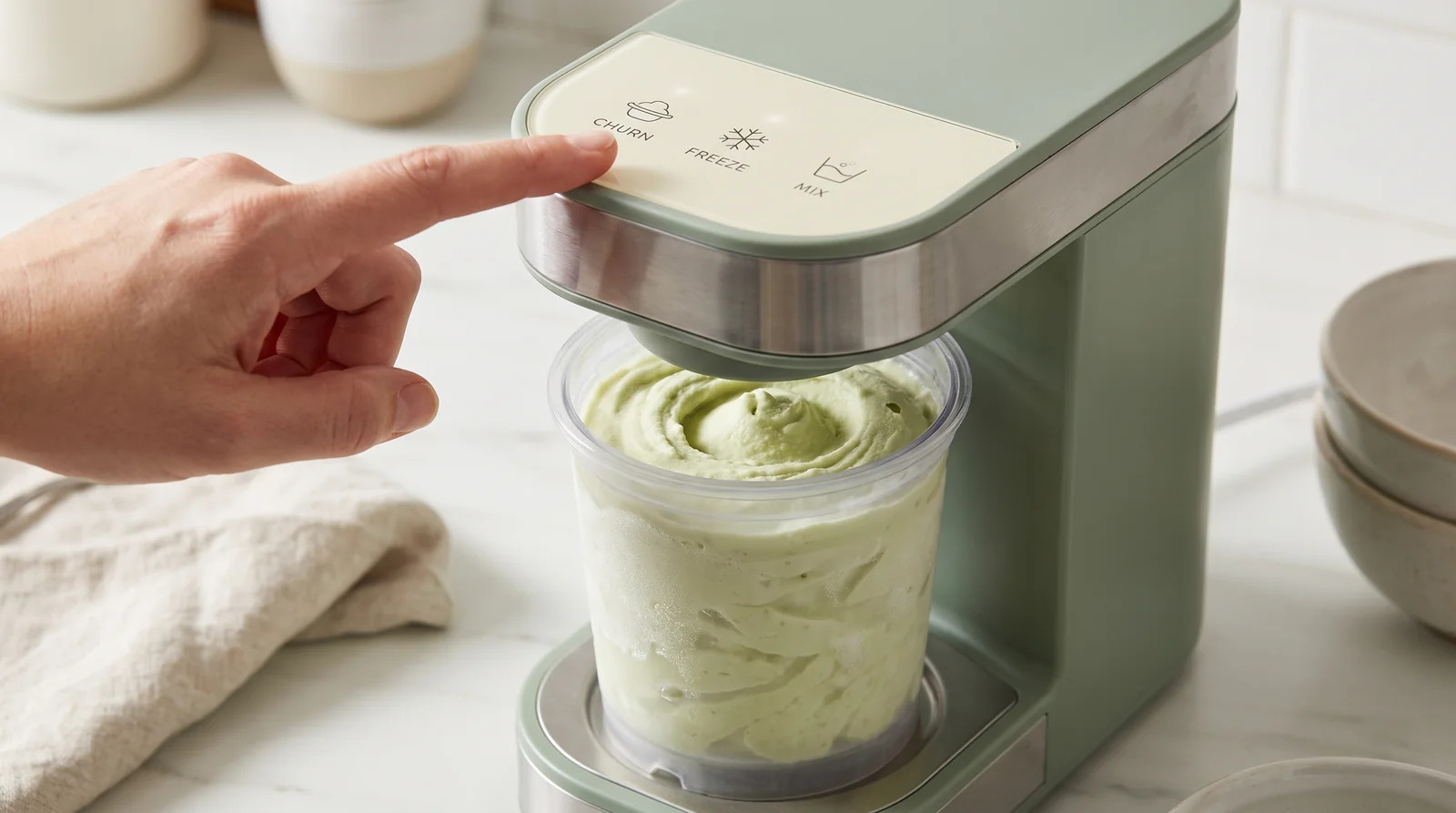 Close-up of an ice cream maker control panel with a finger hovering over the program buttons