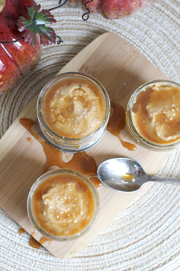 Overhead view of salted caramel pudding cups topped with caramel sauce and sea salt