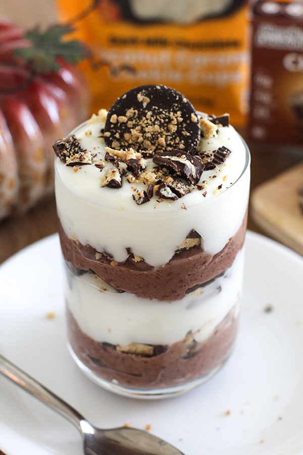 Glass parfait with alternating layers of chocolate pudding, yogurt, and chopped cookie cups