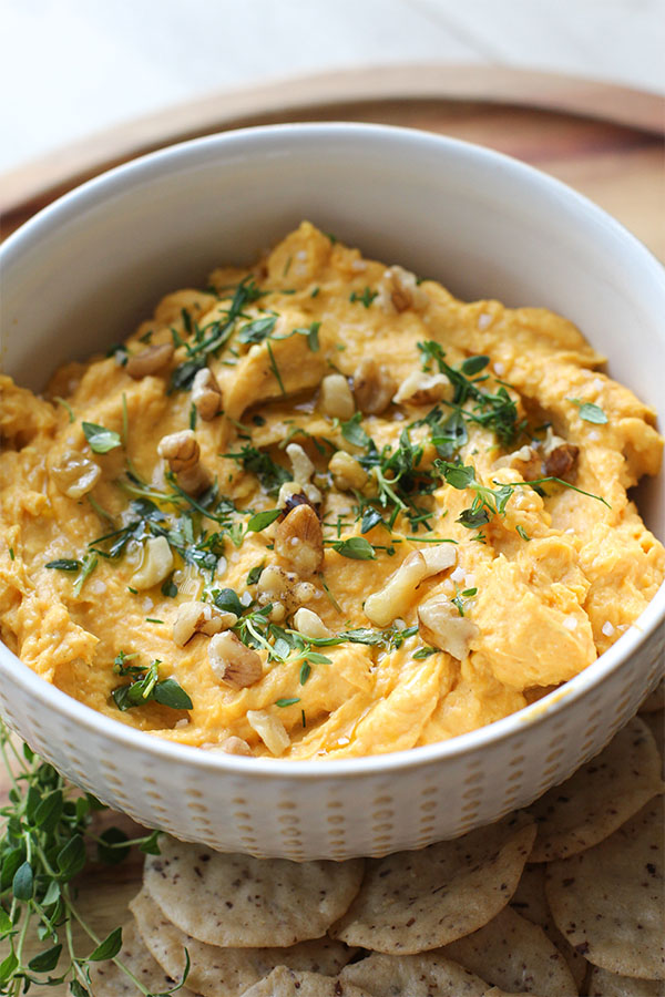Creamy savory pumpkin dip garnished with walnuts and thyme