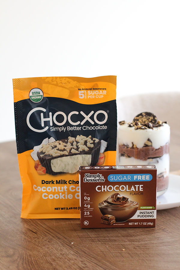 Simply Desserts Chocolate Pudding and Chocxo Dark Milk Chocolate Coconut Caramel Cookie Cups next to a finished parfait