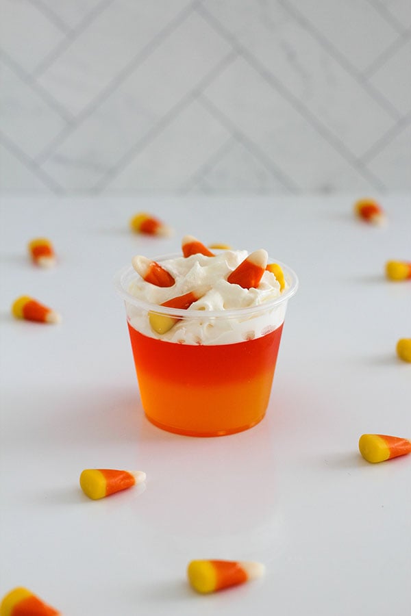 Close-up of layered Candy Corn Jel cup topped with whipped cream and candy corn