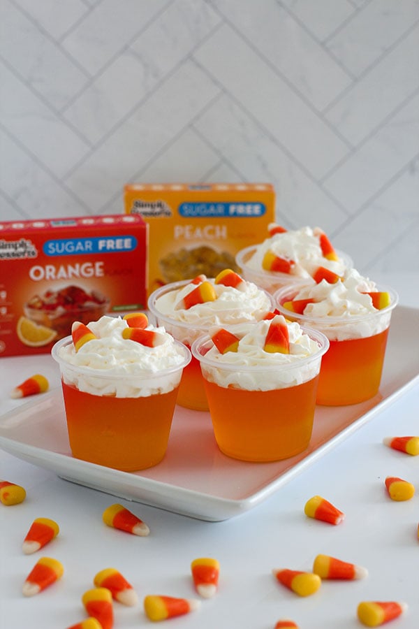 Group of Candy Corn Jel cups with Simply Desserts Peach and Orange Jel boxes behind them
