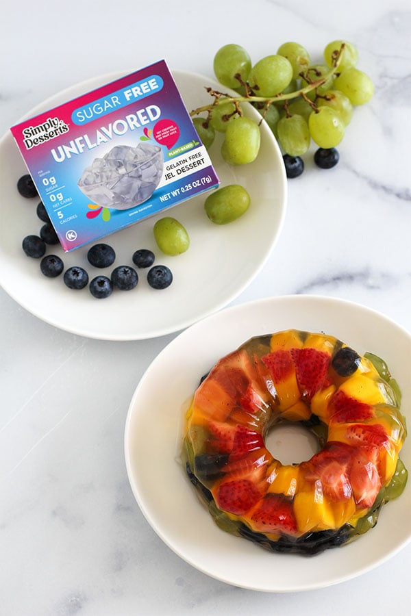 Overhead photo of Fruity Jel Cake and Simply Desserts Unflavored Jel Dessert box with grapes and blueberries
