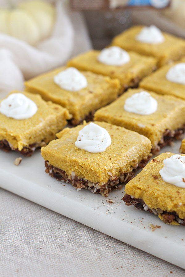 Pumpkin pie bars showing the textured pecan-date base and smooth pumpkin topping