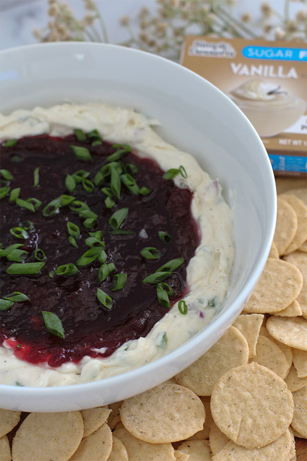 Overhead view of creamy cranberry jalapeño dip served with almond crackers