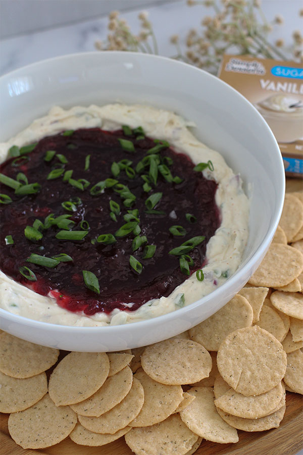 Close-up of creamy dip with cranberry topping and diced green onions