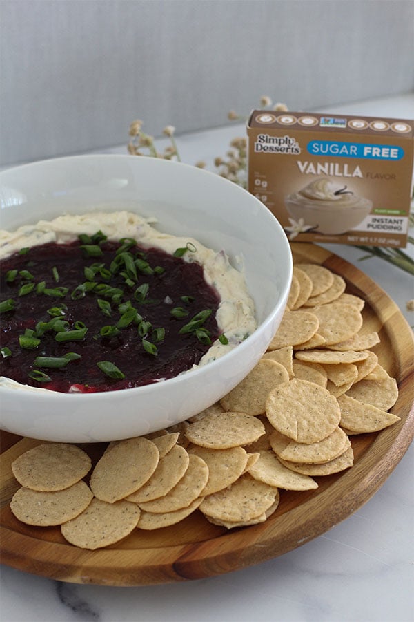 Bowl of vegan cranberry jalapeño dip made with Simply Desserts Vanilla Pudding, topped with green onions